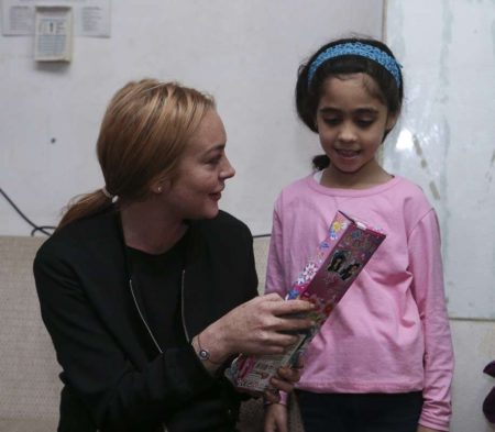 ISTANBUL,  TURKEY - SEPTEMBER 26: Hollywood actress Lindsay Lohan (L) gives present to a Syrian refugee girl at her house after the visit to a hospital built for Syrian refugees at Sultanbeyli suburb of Istanbul,  Turkey on September 26,  2016. (Photo by Stringer/Anadolu Agency/Getty Images)