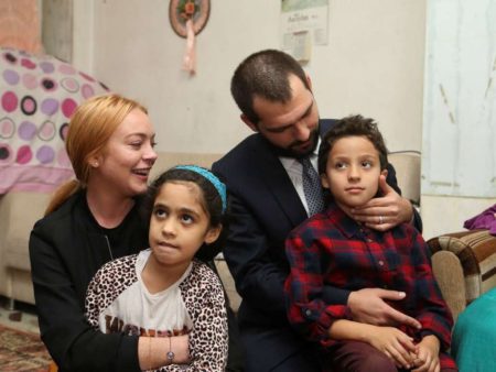 ISTANBUL,  TURKEY - SEPTEMBER 26: Hollywood actress Lindsay Lohan (L) and Turkey's Deputy Minister of Youth and Sports Abdurrahim Boynukalin (R) pose with a Syrian refugee kids at their house after the visit to a hospital built for Syrian refugees at Sultanbeyli suburb of Istanbul,  Turkey on September 26,  2016. (Photo by Stringer/Anadolu Agency/Getty Images)