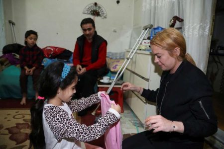 ISTANBUL,  TURKEY - SEPTEMBER 26: Hollywood actress Lindsay Lohan (R) gives present to a Syrian refugee girl at her house after the visit to a hospital built for Syrian refugees at Sultanbeyli suburb of Istanbul,  Turkey on September 26,  2016. (Photo by Stringer/Anadolu Agency/Getty Images)