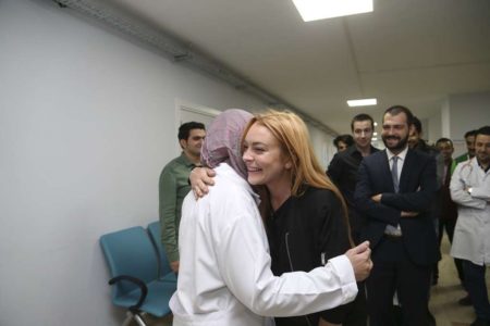 ISTANBUL,  TURKEY - SEPTEMBER 26: Hollywood actress Lindsay Lohan (2nd L) hugs with a Syrian refugee during her visit to a hospital built for Syrian refugees with the Turkey's Deputy Minister of Youth and Sports Abdurrahim Boynukalin (2nd R) at Sultanbeyli suburb of Istanbul,  Turkey on September 26,  2016. (Photo by Stringer/Anadolu Agency/Getty Images)
